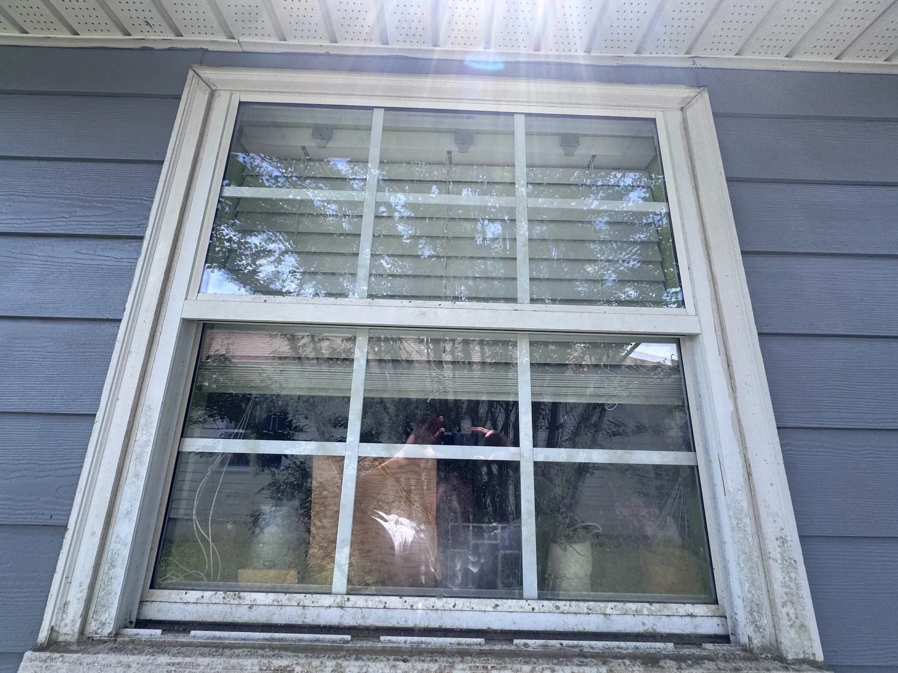 Residential window with mineral buildup in Tallahassee — before cleaning